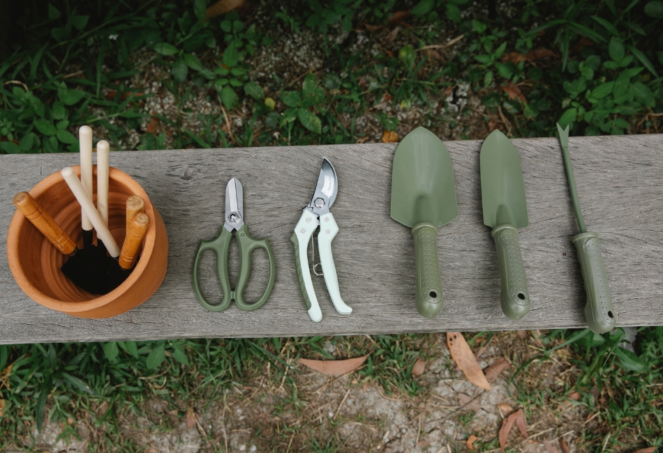 Outils-de-jardinage Outils de jardinage comme des pelles et des ciseaux posés sur un banc